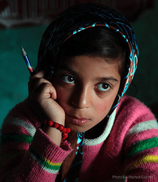 Young girl thinking and holding a pen
