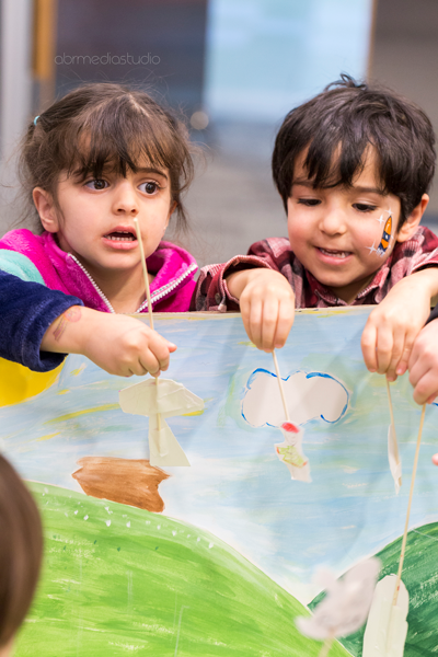 Two little kids playing a puppet show