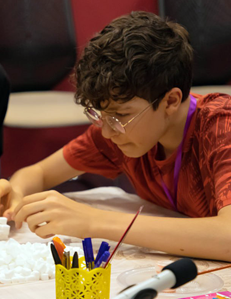 Student is building a 3D structure with sugar cubes
