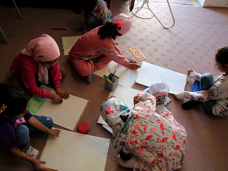 Group of children sitting on the floor and drawing