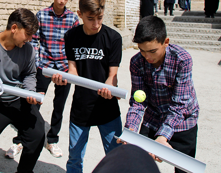 Three boys trying to create a marble run