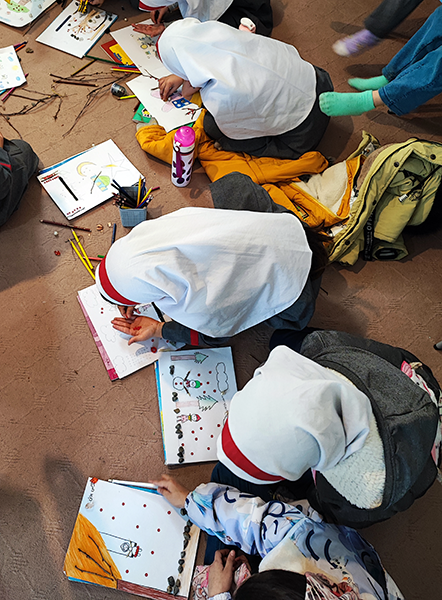 Group of young girls sitting on the floor and drawing