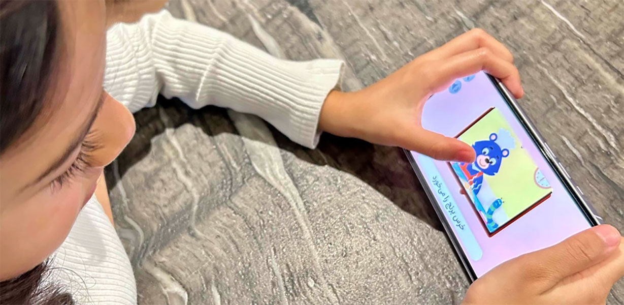 Little child playing with TooTak application on a cellphone